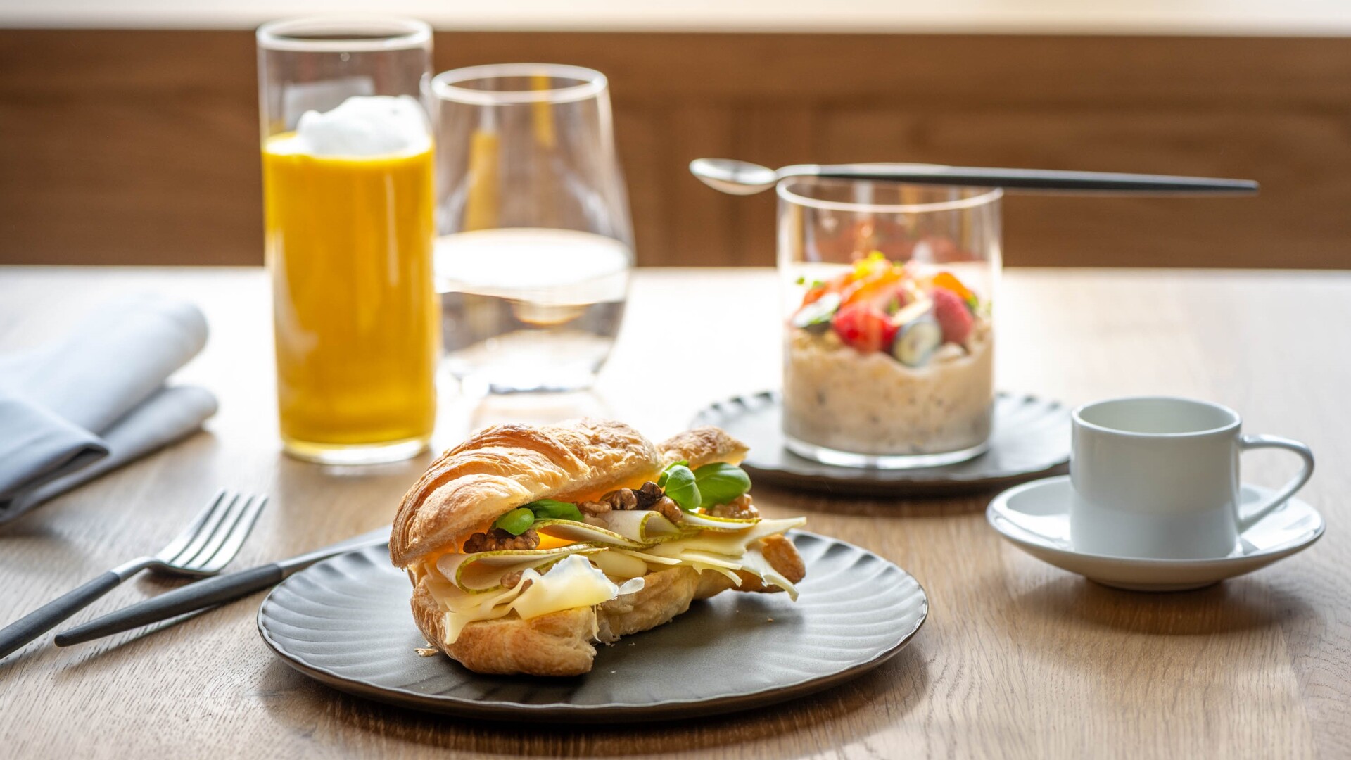 Serviertes Frühstück im Seegut Zeppelin mit gefülltem Croissant, Bircher-Müsli im Glas, Goldener Milch und Kaffee