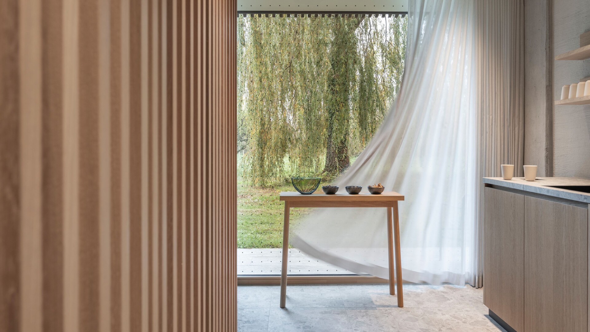 Wellnessbereich im Garten Spa des Seegut Zeppelin mit rundem, hinterleuchtetem Spiegel, Waschtisch und Naturstein