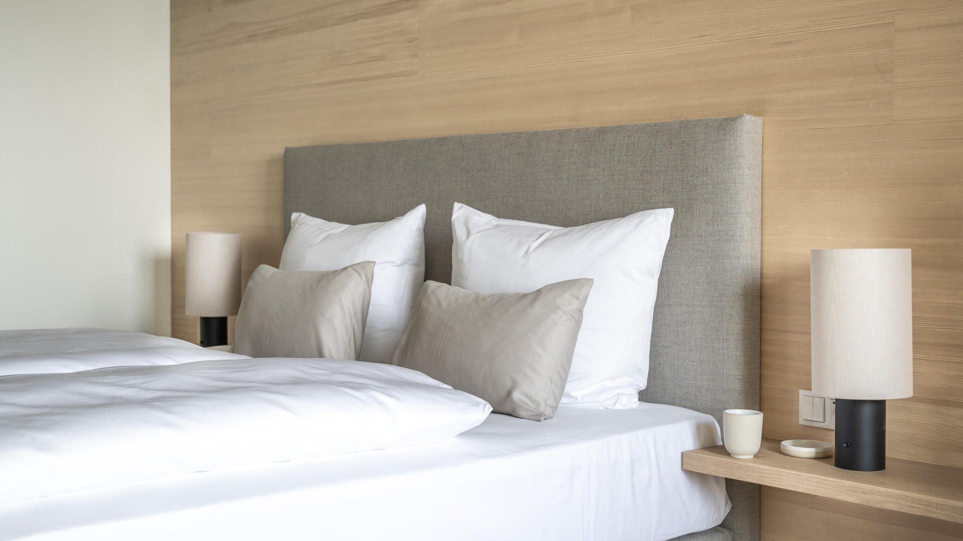 Hotelzimmer im Seegut Zeppelin mit Boxspringbett und Wandverkleidung aus Weißtanne