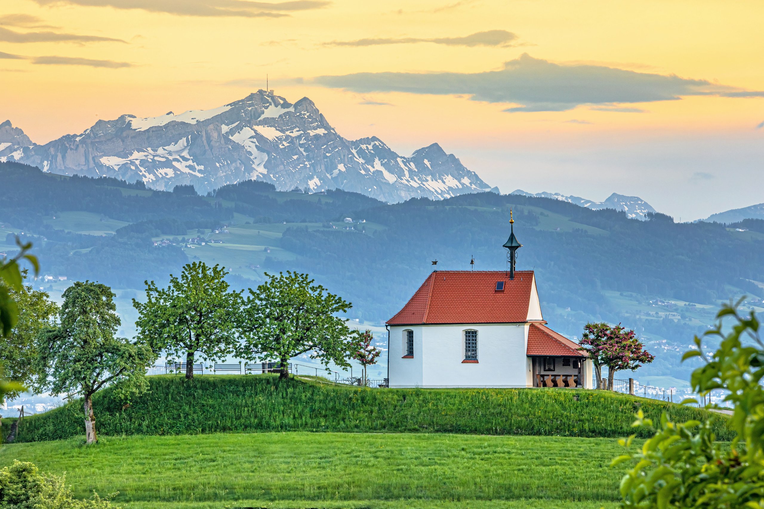 Kapelle auf einem Hügel vor dem Säntis im Abendlicht, Blick vom Bodensee in die Schweizer Alpen