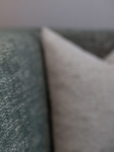 Detailaufnahme einer grünen Polsterbank mit gefalteter Serviette im Restaurant Pinus der Villa Gminder