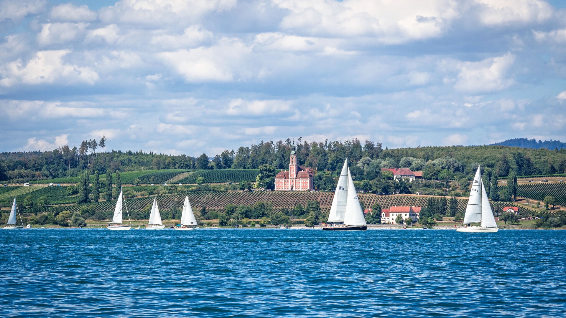Landgang und Seegang am Bodensee Segelboote auf dem Bodensee vor dem Ufer mit der Wallfahrtskirche Birnau