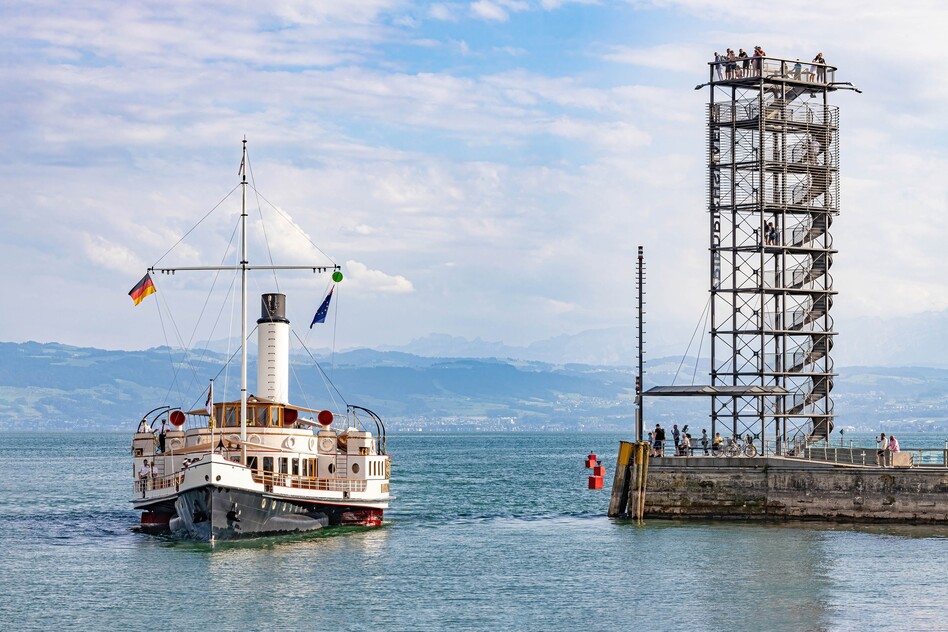 Historischer Raddampfer Hohentwiel auf dem Bodensee neben einem Steg mit Aussichtsturm